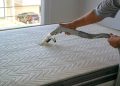 Photo of a person cleaning a mattress.