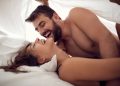 Young smiling man and woman making love in bedroom