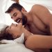 Young smiling man and woman making love in bedroom