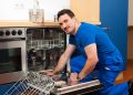 Technician or plumber repairing the dishwasher in a household