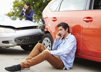 Teenage Driver Making Phone Call After Traffic Accident Sitting Next To Crash.