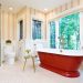 A contemporary modern bathroom design. featuring a contemporary classic freestanding cast iron bathtub against a scenic window.
