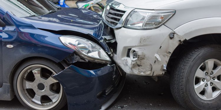 Car crash from car accident on the road in a city between saloon versus pickup wait insurance.